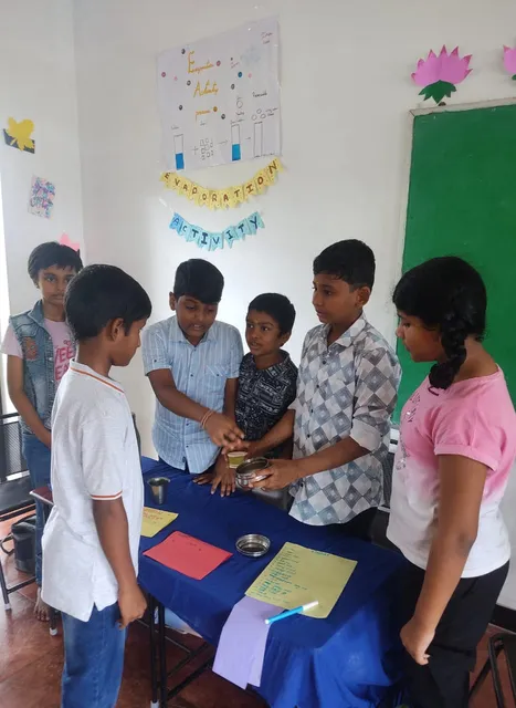 Excited students at Vidhya Peetham i-School observing ice cubes melting and refreezing, demonstrating the concepts of melting and freezing in their practical science session.