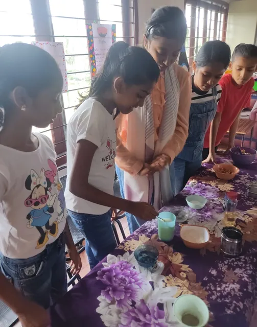 Fifth-grade students at Vidhya Peetham i-School engaging in a group science experiment, exploring solubility by mixing various substances in water, as part of their states of matter activity.