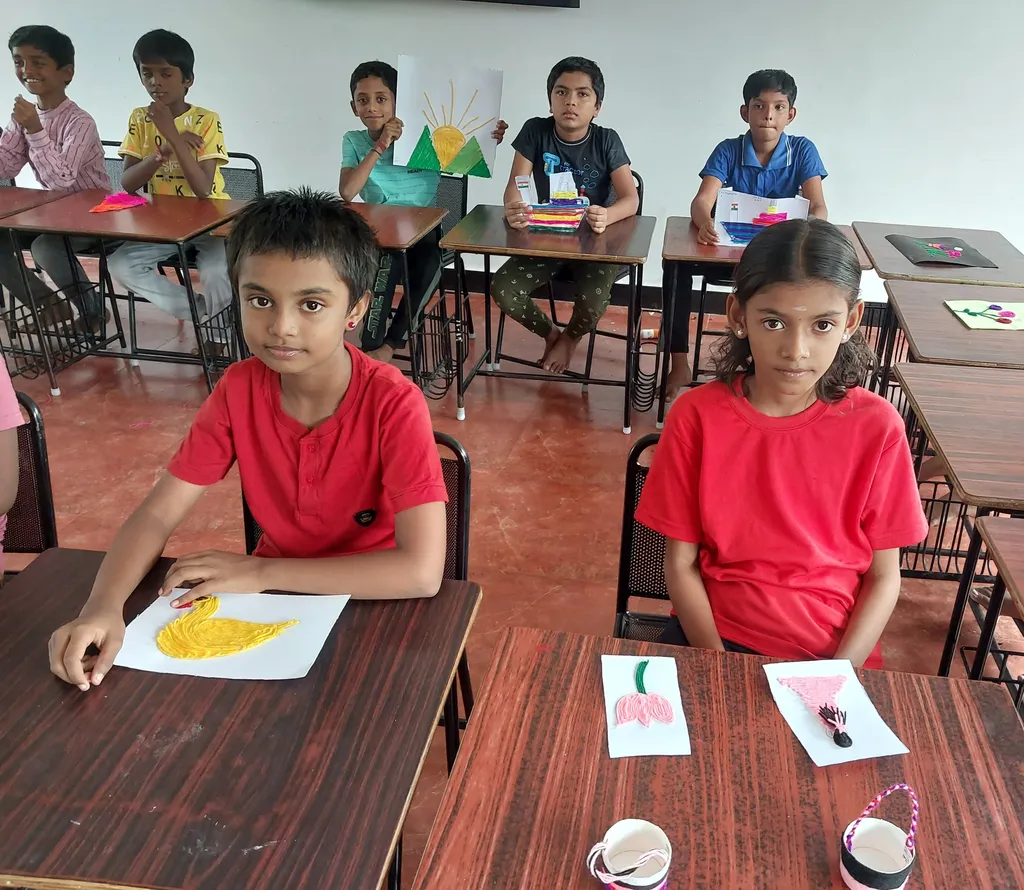 Fifth-grade students at Vidhya Peetham i-School in Salem concentrating on their yarn art projects, with colorful yarn and craft tools spread out on their desks.
