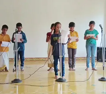 A group of young actors from Grade 3b practicing their lines into microphones, dressed in vibrant character costumes, at the best CBSE school in Salem.