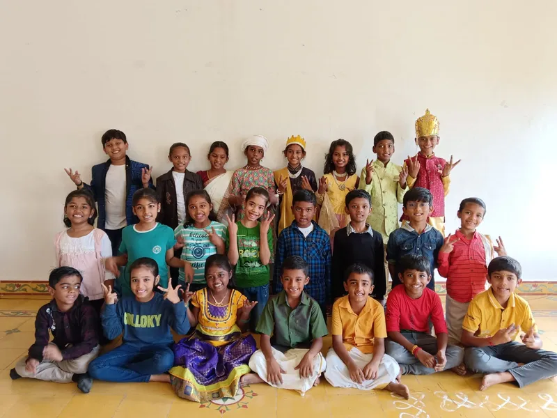Happy and excited third graders posing in colorful attire, giving peace signs, after their successful Closet Drama performances at one of the top schools in Salem.
