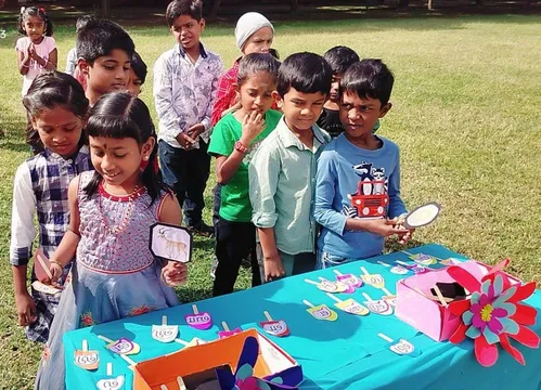 Eager Grade 1 students selecting Tamil letter flashcards from a table during the Eluthugalai Kondu Sol Uruvaakuthal Activity at a leading CBSE school in Salem.