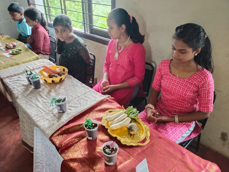 Eager young learners at one of the best schools in Salem holding a cauliflower and broccoli, exploring food from flowers during a class activity.