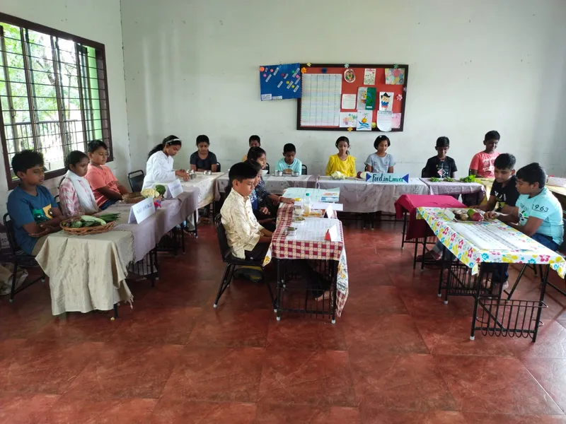 Students of a top CBSE school in Salem proudly exhibit a basket of fresh vegetables, identifying stem and root foods as part of their science curriculum.