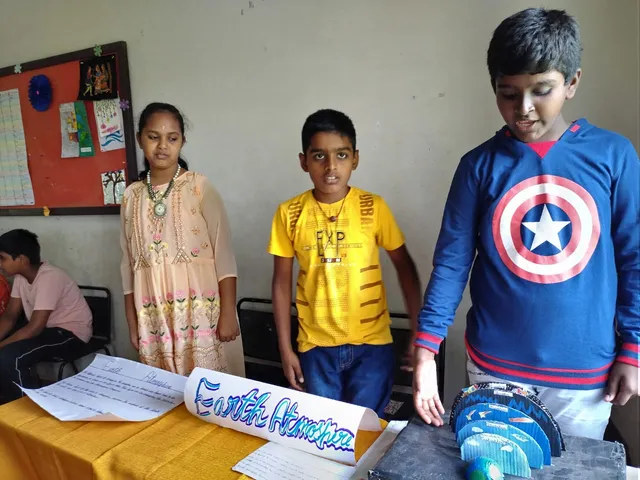 Grade 6 students presenting an Earth's atmosphere model at the Cultural and Heritage Expo in a Salem CBSE school.