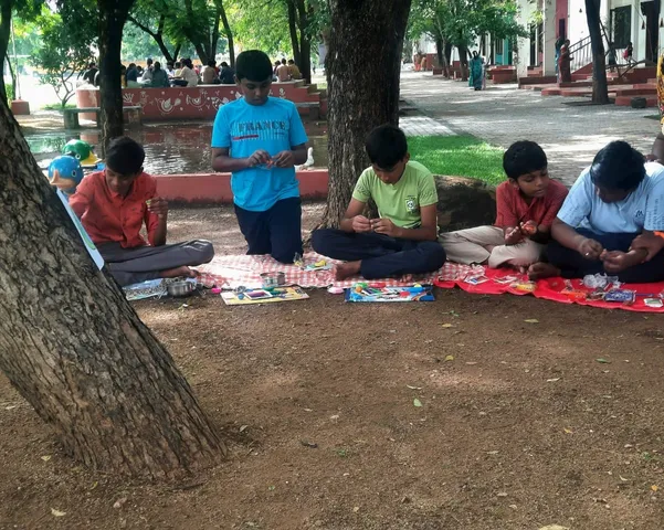 Grade 7 students of a top school in Salem engaging in a playdough earth layering activity under a lush tree.
