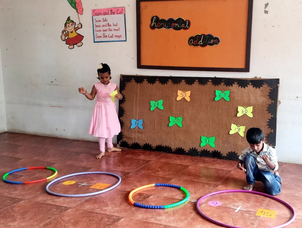 UKG Horizontal addition 1_result Dedicated students at a leading school in Salem engaging in horizontal addition with creative floor mats and paper butterflies, showcasing fun learning methods.