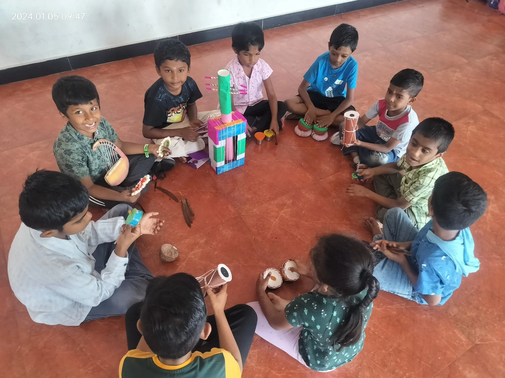 Students in a circle, sharing and playing their sustainable musical creations, fostering a love for eco-music at Salem's best CBSE school. ?♻️