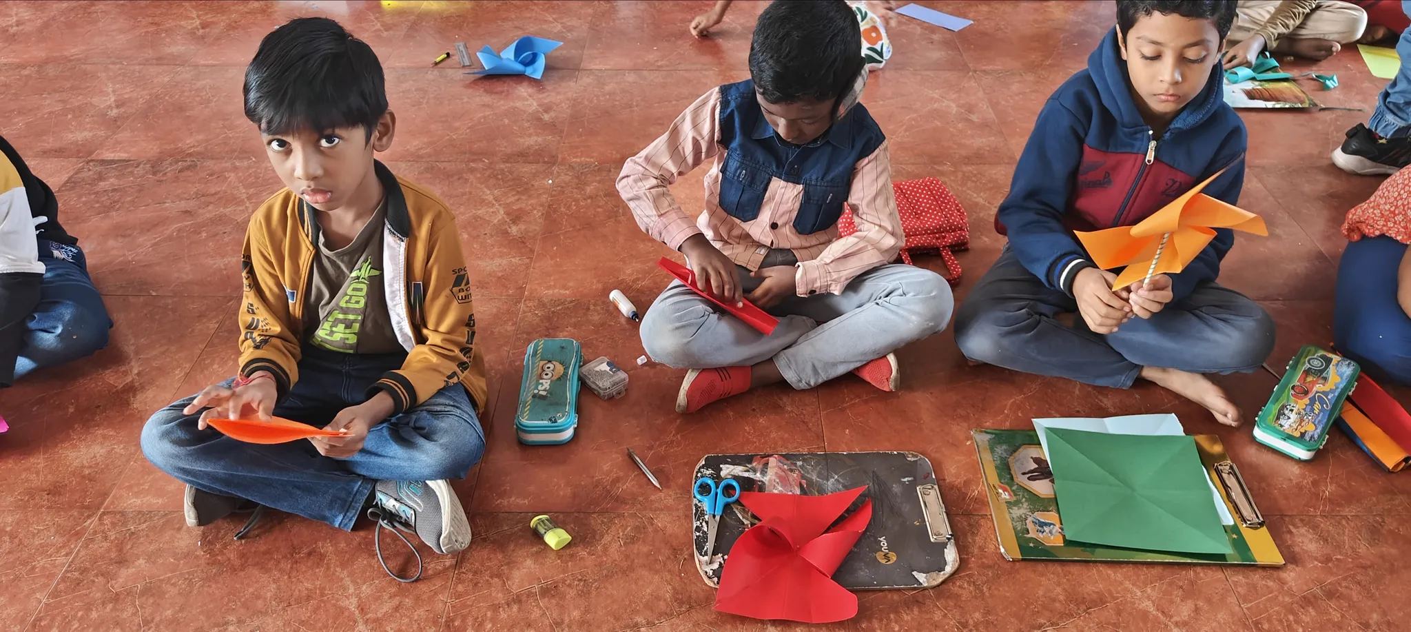 Focused children at Vidhya Peetham i-School in Salem creating pinwheels for pinwheel activity with colorful papers and crafting tools.