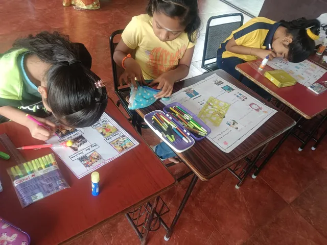 A group of creative children at Vidhya Peetham i-School immersed in crafting their rule-themed posters with various art supplies.
