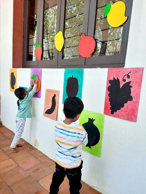 PreKG children collaborating in fruits kindergarten identification game, enhancing their knowledge of fruits in a playful environment.