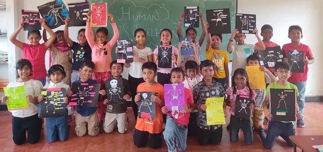 Proud Grade 4 students holding up their creative skeleton projects in a classroom at a Salem CBSE school.