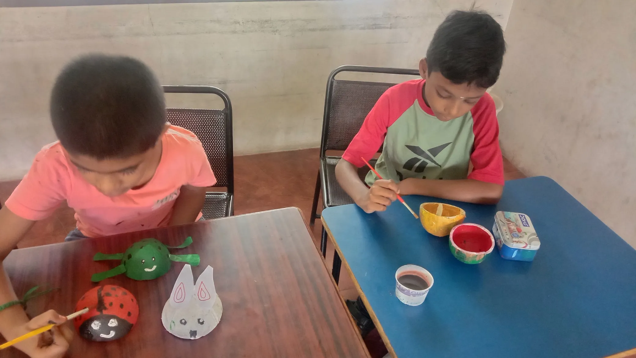 Children engaged in painting colorful designs on coconut shells at Vidhya Peetham i-School.