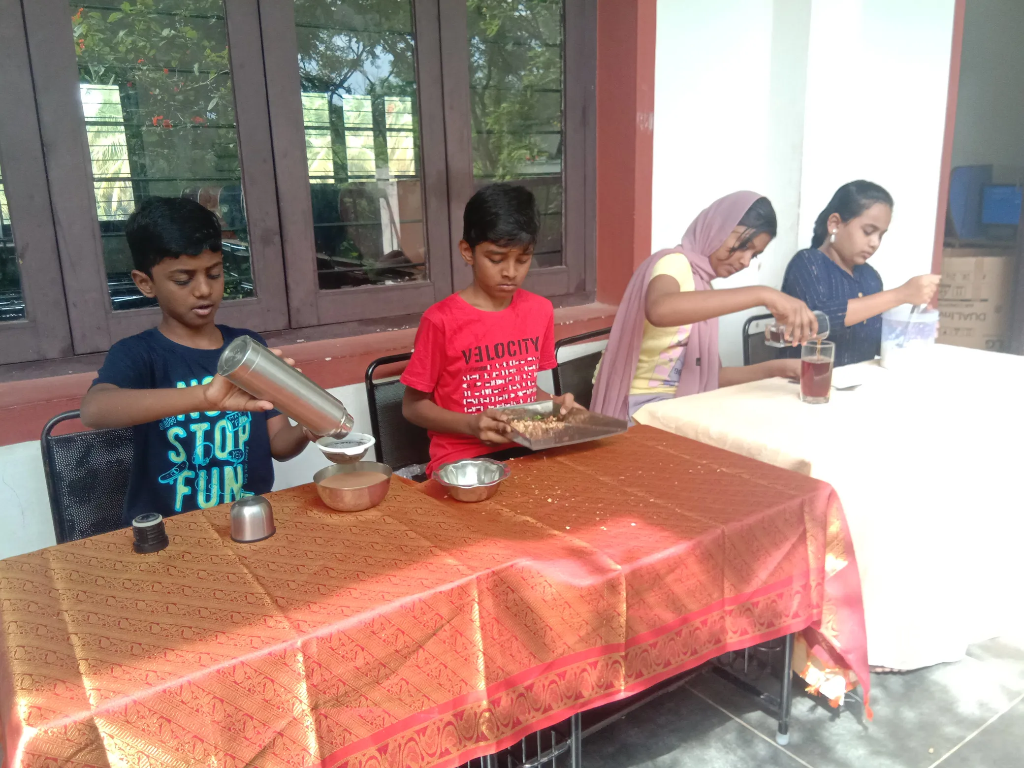 Group of students enthusiastically filtering tea and juices.