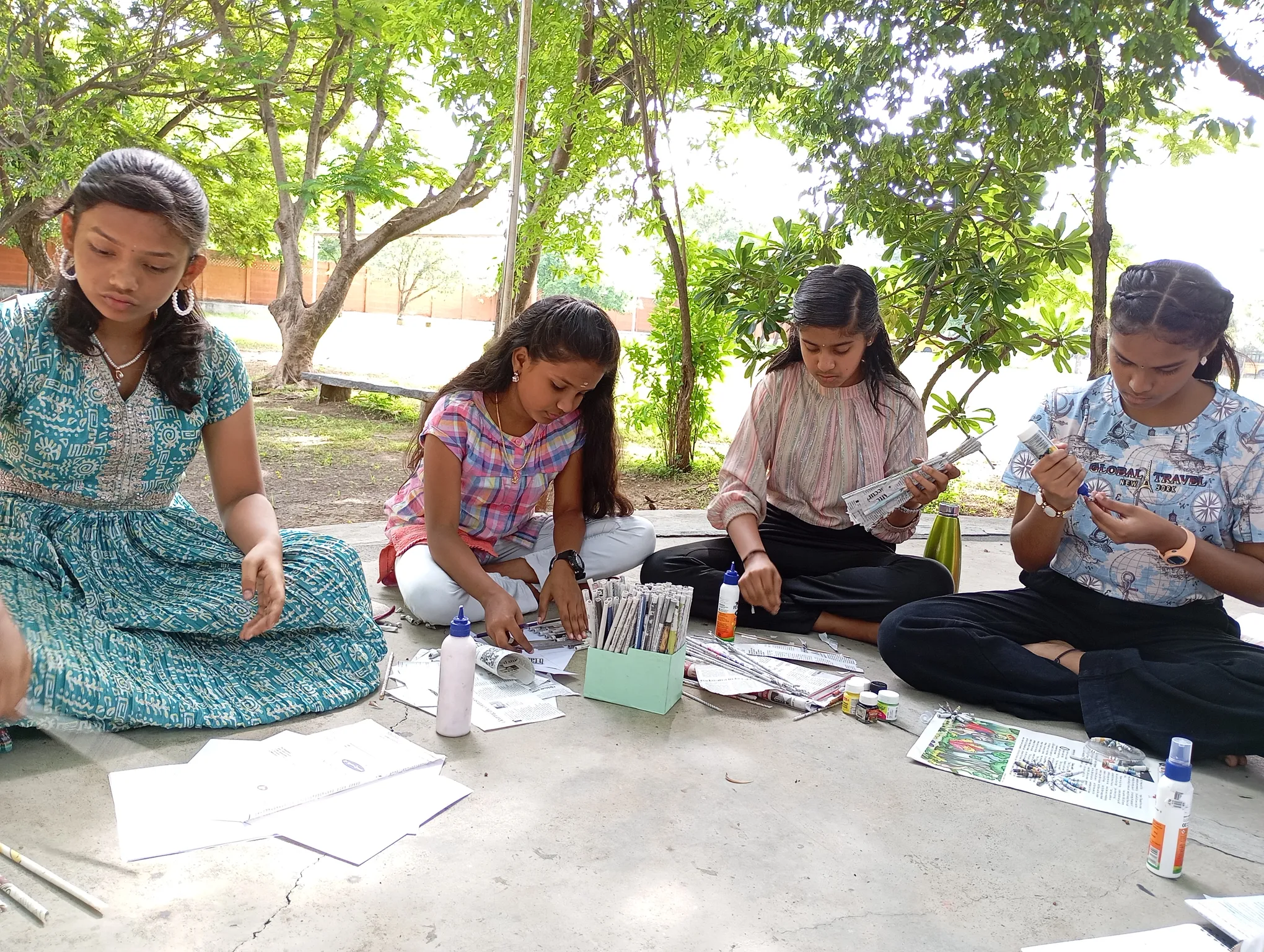 Group of girls working on newspaper crafts at Vidhya Peetham i-School.
