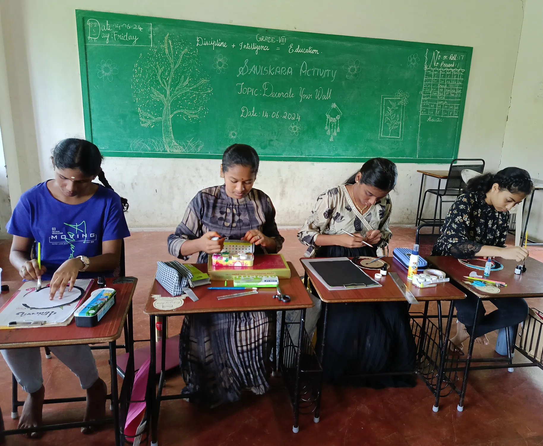 Girls creating decorative wall hangings with color papers at a Salem school.
