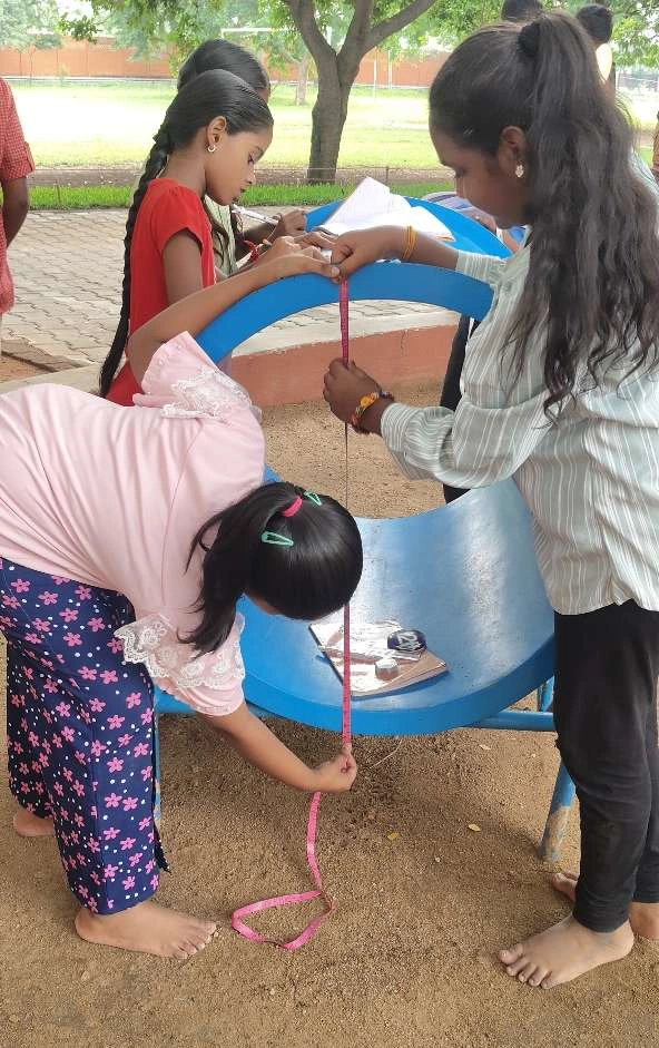 IMG20240816093629_copy_592x941_1 Students measuring the diameter of playground equipment to calculate its circumference at the best CBSE school in Salem.