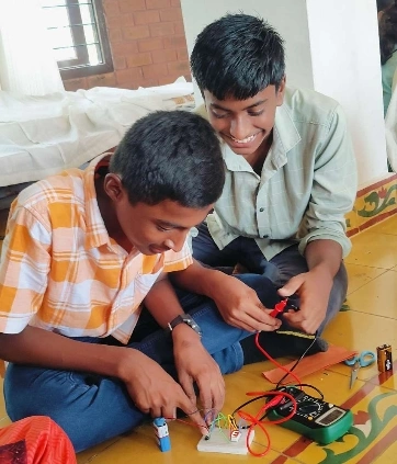 Participants working with resistors and LEDs during a practical session in the electronics workshop.