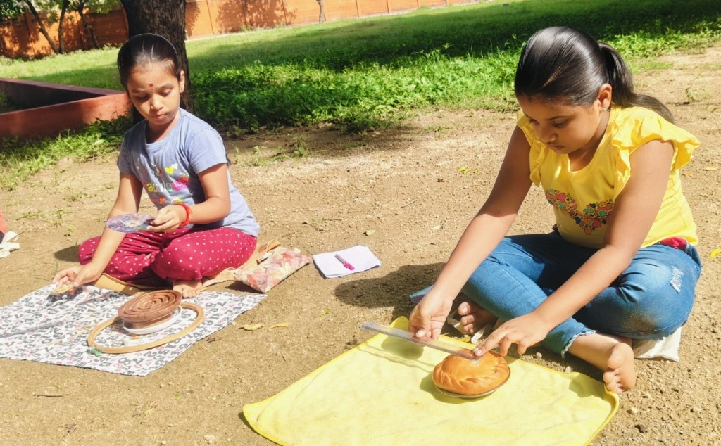Two girls measuring circular eatable items like buns and Murukku to find the radius and diameter
