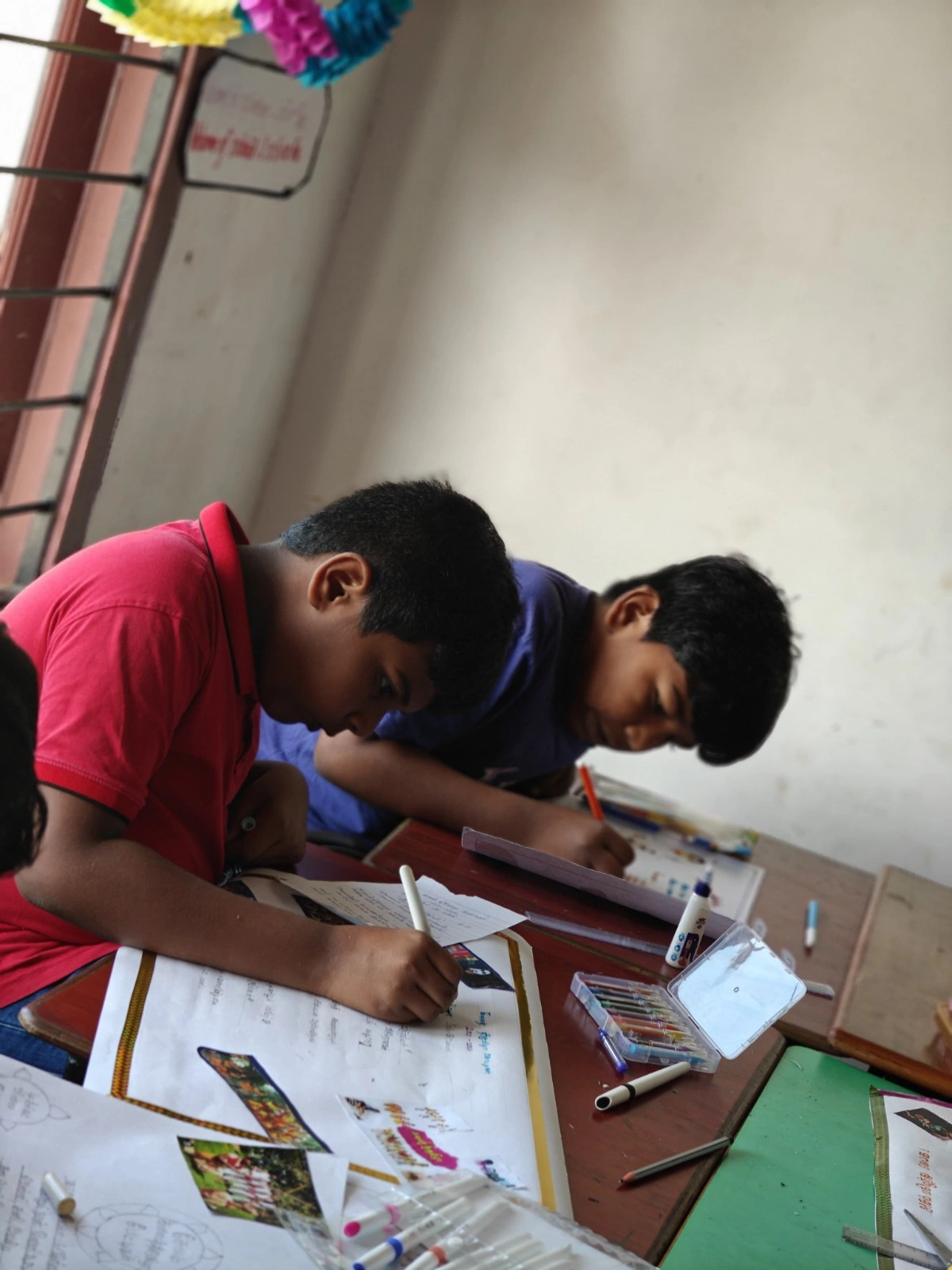Students engaged in the process of designing advertisements during Tamil activity