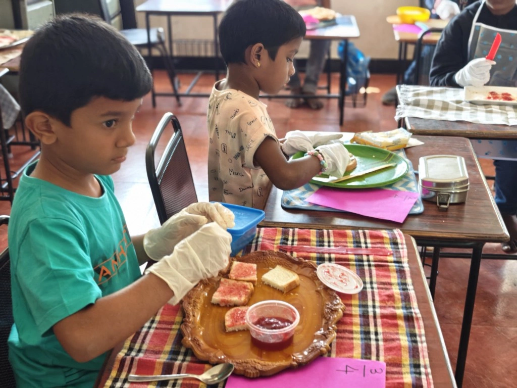 Student practicing fractions by carefully spreading jam on divided bread pieces