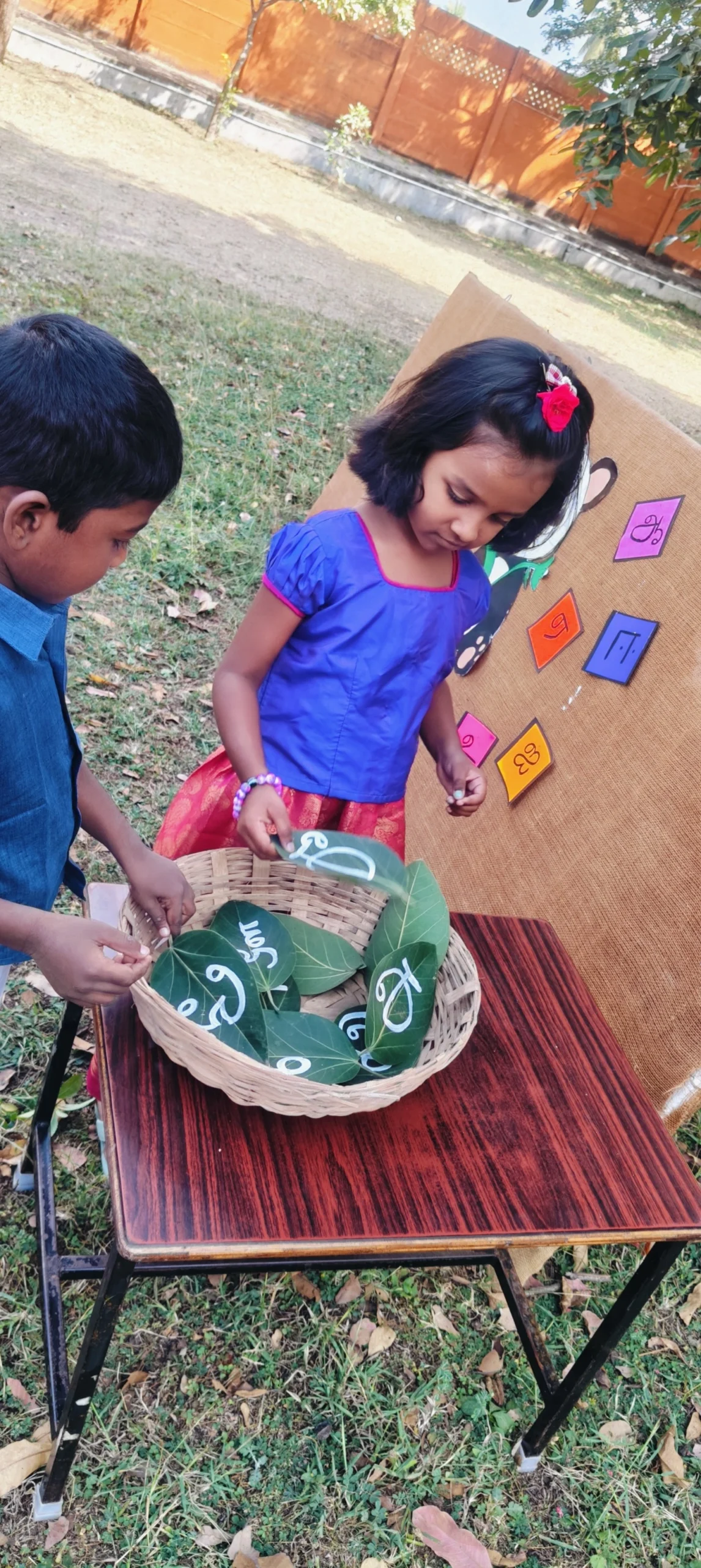 Interactive Tamil letter learning session with children and panda mascot board
