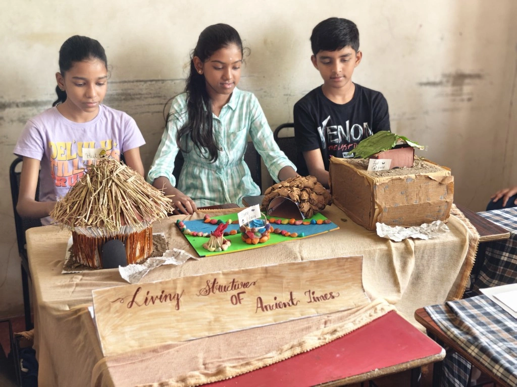 Students showcasing living structures models from ancient times at history exhibition