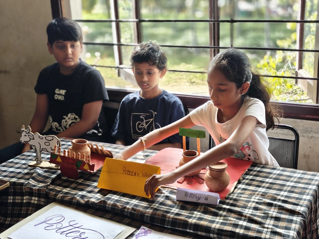 Students learning about pottery and ancient crafts at pottery workstation during Museum exhibits activity