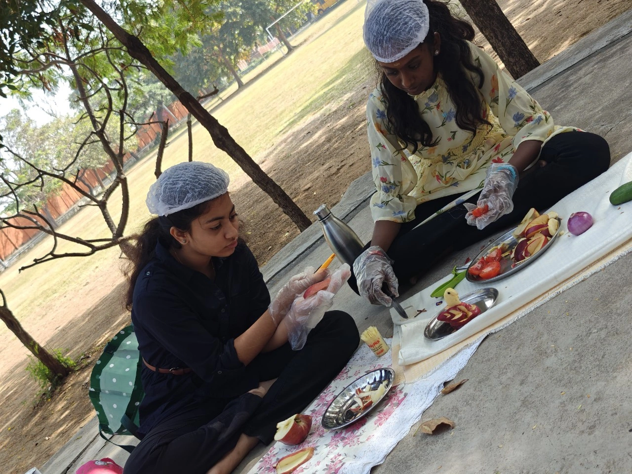 Students demonstrating precision in fruit carving techniques outdoors