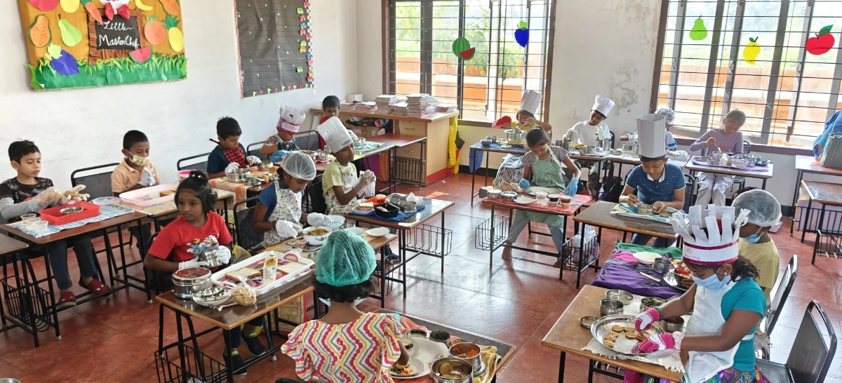 Panoramic view of Grade 2 students engaged in flameless cooking with colorful fruit decorations"