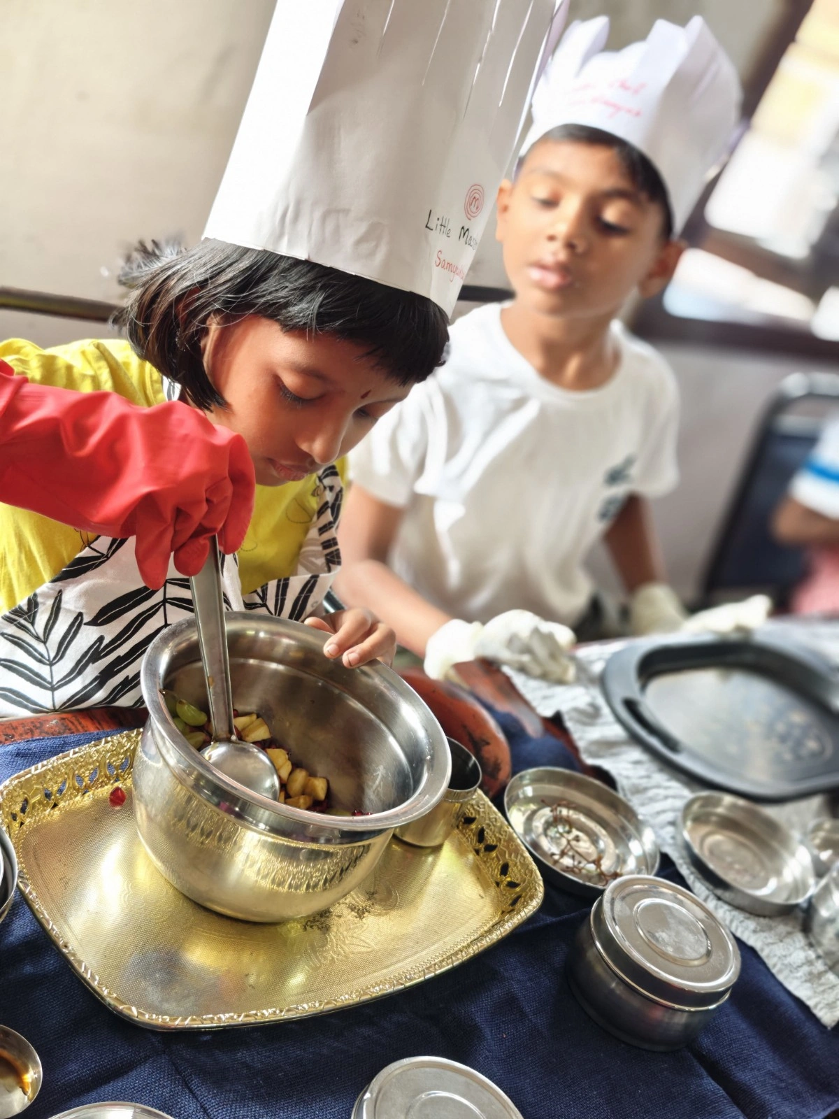 Close-up of two students collaborating on food preparation wearing protective gear