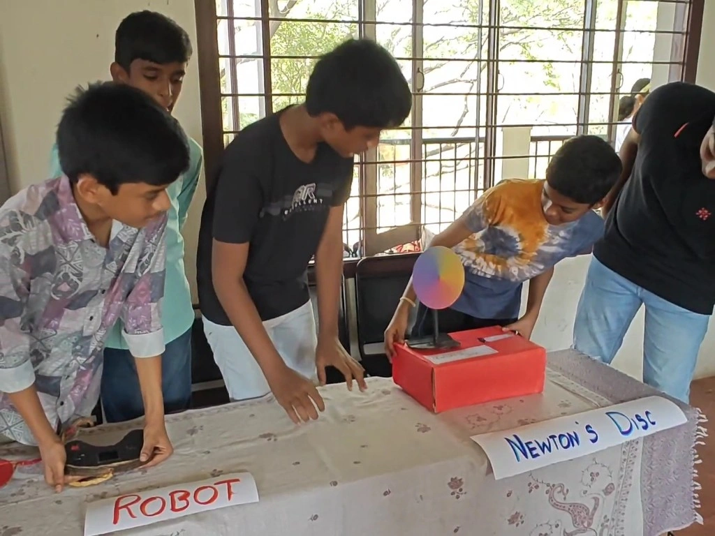 IMG_20250201_17154162_copy_1024x768 Students demonstrating their Newton's Disc and robot projects with detailed labels