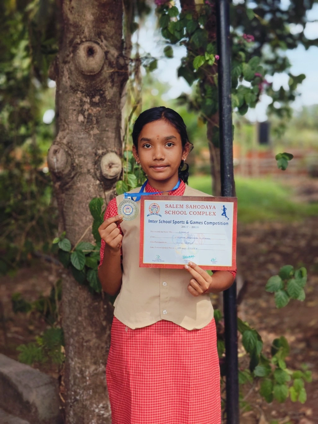 Grade 6 student Isha displaying silver medal certificate from Salem Sahodaya 100m running race at top schools in Salem