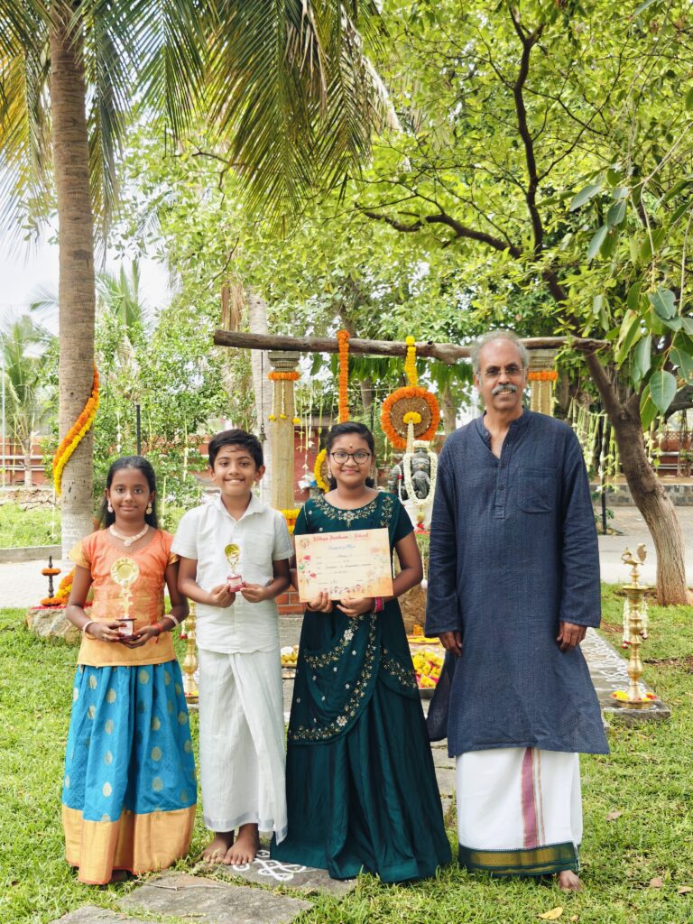 Three children holding trophies and a certificate stand with an adult in front of the shrine