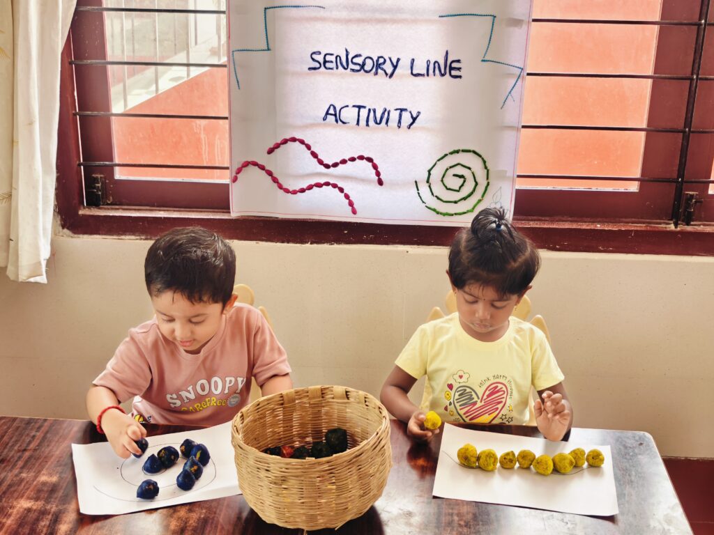 Two children either side of a woven basket place blue and yellow pieces along lines on paper.